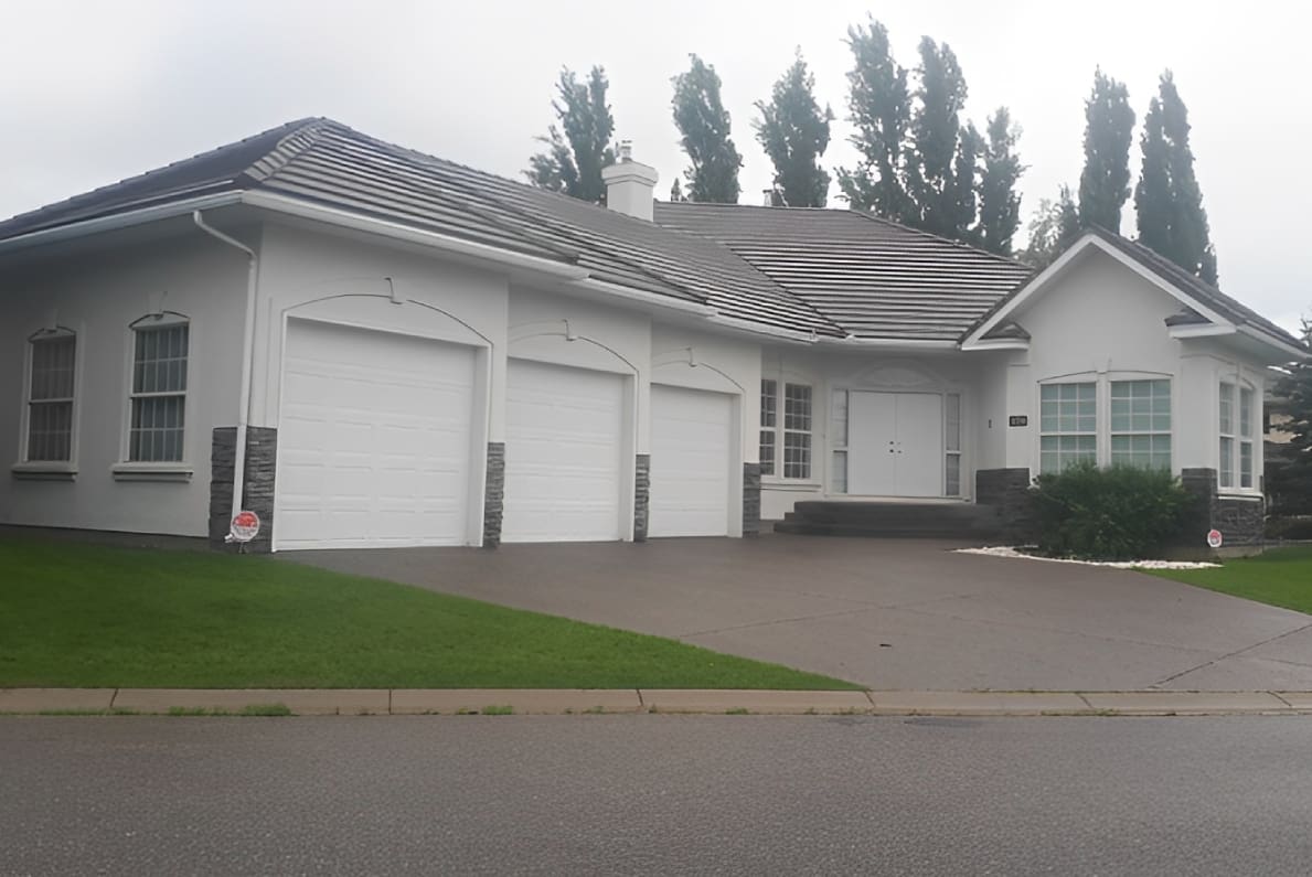 Modern house with a three-car garage on a cloudy day.